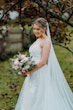 Bride wearing Lettie wedding dress by Rebecca Ingram holding a bouquet