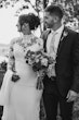 Bride Wearing Crepe And Lace Bridal Dress Called Dionne By Rebecca Ingram With Groom Holding A Bouquet