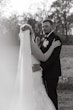 Bride Wearing Lace Mermaid Wedding Gown Called Toccara By Maggie Sottero With a Long Simple Veil With Groom