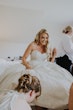 Bride Wearing Sparkly Aline Wedding Dress Called Anniston Getting Her Shoes On With Help From Her Bridesmaids