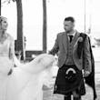 Bride wearing Iris wedding dress by Rebecca Ingram with her husband holding her train