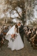 Groom And Bride Share Kiss In Aisle. Bride Wearing Tulle Long Sleeve Ball Gown Called Mallory Dawn By Maggie Sottero