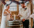 Bride Wearing Simple Fit And Flare Wedding Dress Called Josie By Rebecca Ingram Lighting A Candle With Groom