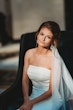 Bride Wearing Sparkly Fit And Flare Wedding Dress Called Anniston Lane By Maggie Sottero Sitting On A Chair