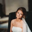 Bride Wearing Sparkly Fit And Flare Wedding Dress Called Anniston Lane By Maggie Sottero Sitting On A Chair