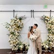 Bride Wearing Lace Fit And Flare Wedding Dress Called Fairchild By Maggie Sottero With Groom Kissing Her Forehead Next To The Flower Arch