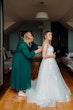 Bride wearing Lettie wedding dress by Rebecca Ingram being buttoned up