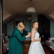 Bride wearing Lettie wedding dress by Rebecca Ingram being buttoned up
