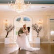 Bride Wearing Lace Long Sleeve Aline Wedding Dress Called Winter By Maggie Sottero With Groom Under A Chandelier