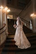 Bride Wearing Lace A-Line Wedding Dress Called Tuscany Lane By Maggie Sottero Walking Up A Grand Staircase