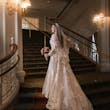 Bride Wearing Lace A-Line Wedding Dress Called Tuscany Lane By Maggie Sottero Walking Up A Grand Staircase