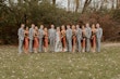 Bride with wedding party wearing simple sheath wedding dress with V-neck.