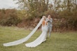 Bride with groom wearing simple sheath wedding dress with V-neck.