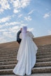 Bride wearing Juniper by Sottero and Midgley walking up stairs with her husband