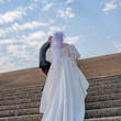 Bride wearing Juniper by Sottero and Midgley walking up stairs with her husband