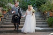 Bride wearing Iris wedding dress by Rebecca Ingram holding hands with her husband