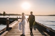 Bride Wearing Beaded Wedding Dress Called Luella By Sottero And Midgley Walking With Groom Along A Pier