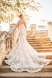 Bride Wearing Glamorous Lace And Sequin Wedding Dress Called Tuscany By Maggie Sottero On Stairs Showing Back Long Train