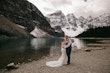 Bride wearing Nelly wedding dress by Rebecca Ingram with her husband in front of mountains