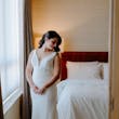 Bride Wearing Simple Wedding Dress Called Theodora By Rebecca Ingram In A Hotel Room