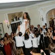 Bride Wearing Satin Aline Wedding Dress Called Ekaterina By Maggie Sottero Being Lifted Up On A Chair