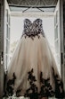 Gothic Black Lace Wedding Dress Called Tristyn By Maggie Sottero Hanging From A Window