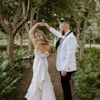 Groom Dancing With Bride In A White Strapless Wedding Dress With Bow On The Back Named Mitchell By Maggie Sottero