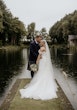 Bride wearing Rousseau wedding dress by Maggie Sottero with her groom