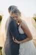 Groom Hugging Bride At Fall Wedding Wearing Ballgown Called Valona by Sottero and Midgley.