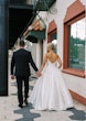 Bride wearing Zinaida by Maggie Sottero walking down the street with her husband