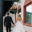Bride wearing Zinaida by Maggie Sottero walking down the street with her husband