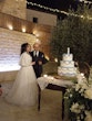 Bride Wearing Glam Long Sleeve Wedding Dress Called Seneca By Sottero And Midgley With Groom Cutting The Cake