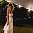 Bride and groom dancing under tent with sparkly fairylights.