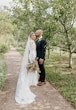 Bride wearing Bethany wedding dress by Rebecca Ingram being kissed by her husband