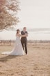 Bride wearing Bridget by Maggie Sottero opening a bottle with her husband