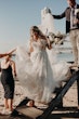 Bride Wearing Off-The-Shoulder Lace Wedding Dress Called Carson By Sottero And Midgley Walking Down The Stairs To The Beach