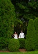 Bride Wearing Simple Fit and Flare Wedding Dress Called Anniston Lane With Groom In A Green Garden