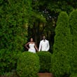 Bride Wearing Simple Fit and Flare Wedding Dress Called Anniston Lane With Groom In A Green Garden