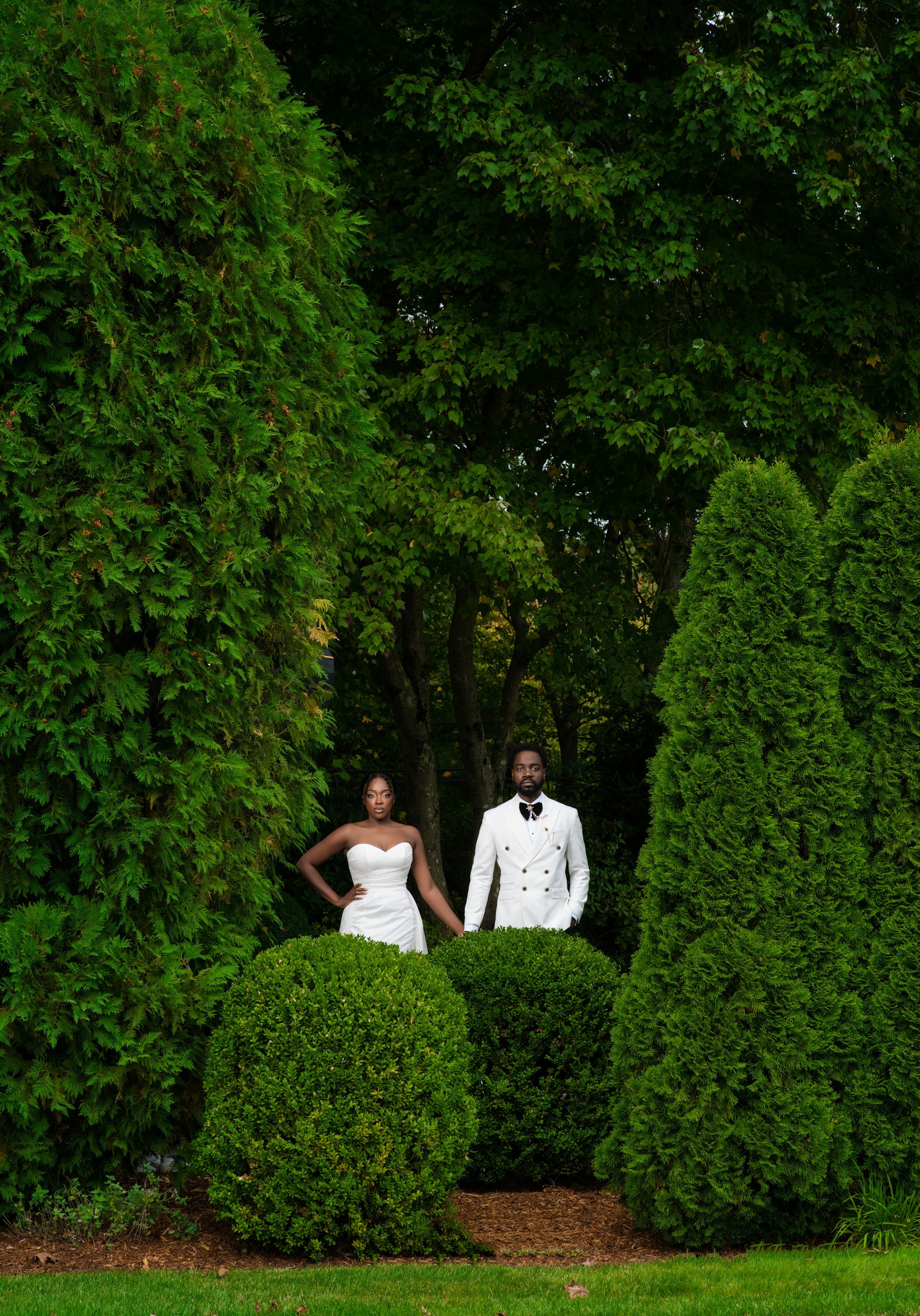 Bride Wearing Simple Fit and Flare Wedding Dress Called Anniston Lane With Groom In A Green Garden