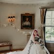 Bride Wearing Gothic Black Lace Wedding Dress Called Tristyn By Maggie Sottero Holding Black and White Floral Bouquet