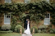 Newlyweds facing each other smiling. Bride wearing wedding dress called Celeste.