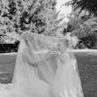 Bride wearing Tuscany Royale by Maggie Sottero playing under her veil with a little girl