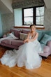 Bride wearing Lettie wedding dress by Rebecca Ingram sitting on a couch