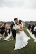 Bride wearing Tuscany Royale by Maggie Sottero kissing her husband at their ceremony