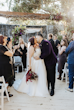 Bride Wearing A-line Bridal Dress Ainsleigh By Rebecca Ingram Kissing Groom With Family Cheering