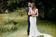 Groom with arms around bride wearing wedding dress called Celeste.