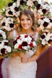 Bride wearing Hamilton wedding dress by Sottero and Midgley surrounded by bouquets