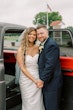 Bride wearing Clover by Rebecca Ingram holding hands with her husband outside of a car