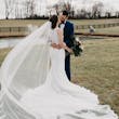 Bride and Groom Kiss With Veil Flowing Behind. Bride Wearing Lace Detailed Halter Wedding Dress Called Kevyn By Sottero And Midgley