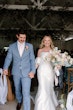 Bride wearing Mitchell by Maggie Sottero holding hands with her husband